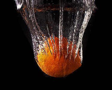 黑底水喷洒中的新鲜柠檬和橘子宏观气泡果汁液体食物活力反射热带飞溅运动图片