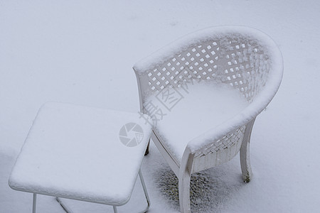白色的桌子和躺椅在冬季覆盖着厚厚的雪层 花园休息室设置在冬季图片