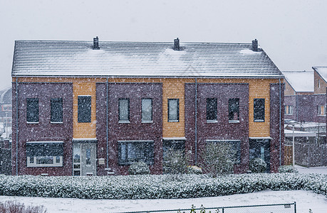 寒冷和寒冬日的梯田式房屋 现代土丘建筑 一个小土丘村降雪图片