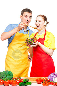 一个男人用木勺子喂一个女孩 用有用的蔬菜S沙拉房子男人桌子女孩成人女士饮食乐趣丈夫图片