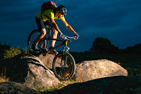 赛车手在夜幕中骑着 落基铁轨上的山地自行车 比赛 极端运动和概念活动下坡头盔踪迹山地车冒险天空车轮男人耐力赛图片