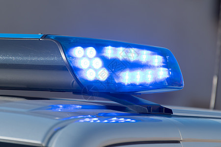 一辆警车上闪亮的蓝色灯光的详细拍摄图片