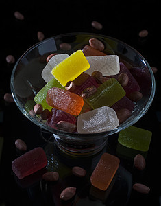 玻璃器件中的糖果立方体果味白色食物花生坚果橙子甜点绿色红色图片