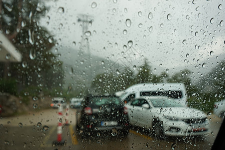 与汽车一起行驶的公路通过车的风挡风玻璃在下雨中拍摄交通窗户液体镜子玻璃路口反射街道蓝色城市图片