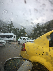 与汽车一起行驶的公路通过车的风挡风玻璃在下雨中拍摄城市窗户天气路口交通雨滴反射玻璃街道蓝色图片