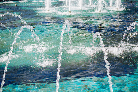 喷泉在游泳池里喷出闪亮的水背景喷射水池淋浴液体飞溅公园图片