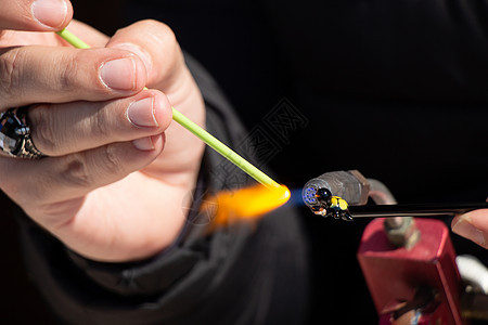 一个人的手做一个玻璃主题商业制造业材料温度燃烧工作鼓风机工具火焰火炬图片