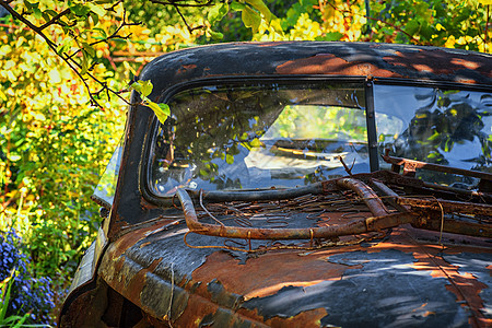 一辆古老的旧旧旧车在夏日站在一条街上 在绿树下图片