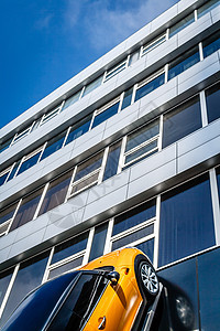 黄色车乘穿过玻璃楼层的摩天大楼图片