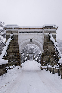 挪威雪雪中旧石板悬浮桥图片