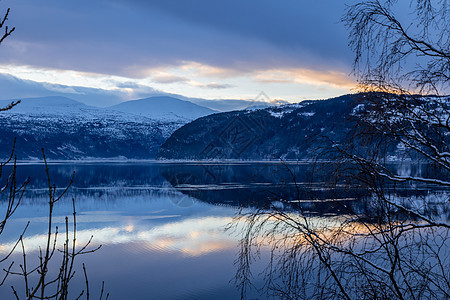 湖上日落和山丘的反射图片