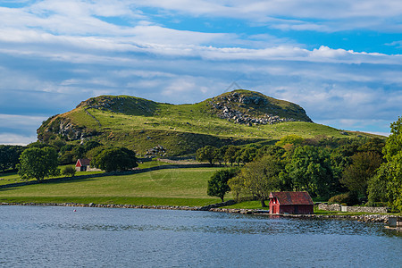 挪威海岸的红木屋绿绿色景观图片