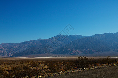 穿过死亡谷国家公园的公路 其背景是帕纳明特山脉Panamint山环境盆地景观荒野极端国家奇观旅行盐滩沙漠图片