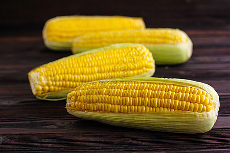 木桌背景的甜玉米植物收成绿色食物粮食蔬菜棒子叶子水果黄色图片