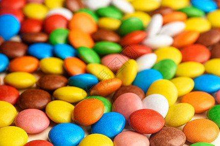 分散在桌上的彩色糖果小吃绿色蓝色巧克力白色圆形团体食物橙子红色图片