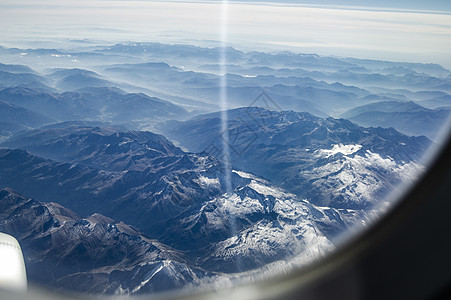 在飞往意大利和奥地利阿尔卑斯山雪封顶峰的飞行中 从飞机窗外看月光下蓝天空的地平线旅行窗户旅游商业顶峰气氛天线高度山脉涡轮图片