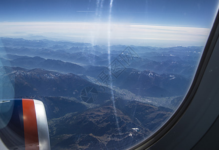 在飞往意大利和奥地利阿尔卑斯山雪封顶峰的飞行中 从飞机窗外看月光下蓝天空的地平线山脉翅膀旅游高山空气旅行天线窗户涡轮天空图片