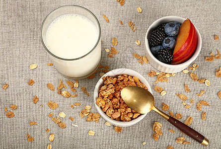 配有酸奶的穆埃斯利颗粒早餐牛奶勺子油桃玻璃营养食物桌布浆果白色水果图片