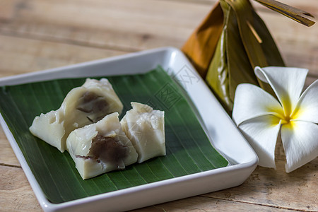 带有椰子填充的蒸汽面粉叶子热带健康美食甜点食物香蕉小吃白色绿色图片