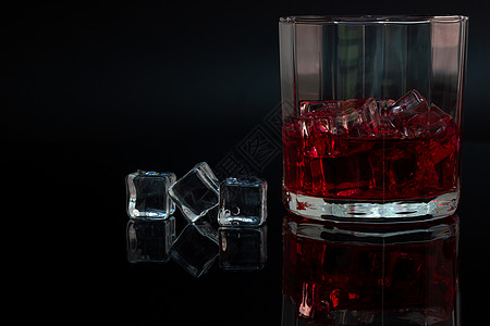 多边形玻璃和深黑背角的酒和冰的反光图片