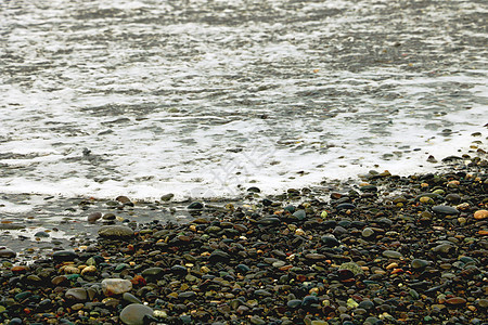 沙滩上的鹅卵石大海翻滚的波浪与泡沫巨石季节岩石假期海滩卵石旅游海洋墙纸海浪图片