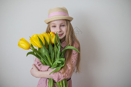 穿粉红裙子的少女 盛着黄色郁金香的大花束图片