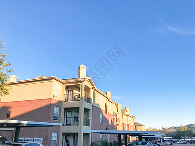 典型的公寓楼里有汽车 在德克萨斯州盖着停车位建筑房子住宅社区住房车库奢华阳台财产天空图片