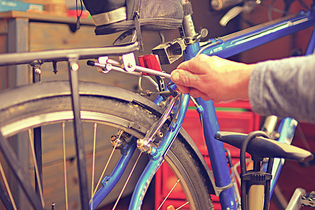 观点男性机械手使用特殊工具修理自行车 选择性焦点图片