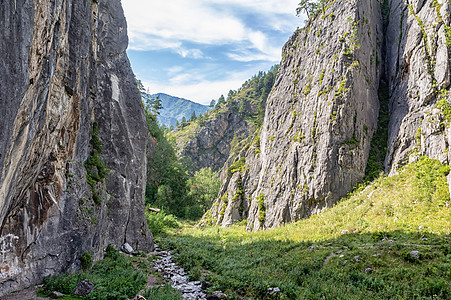 山之间有小溪流瀑布天空自然岩石蓝色山脉旅行公园绿色石头图片