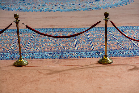 蓝色地毯附近的天鹅绒绳和金属架俱乐部障碍控制贵宾金属展览绳索剧院红色栅栏图片