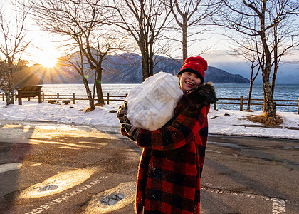 年轻女孩有巨大的雪球日光混血童年微笑手套图片