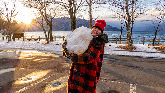 年轻女孩有巨大的雪球混血日光微笑童年手套高清图片