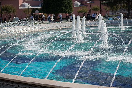 喷泉在游泳池里喷出闪亮的水喷射飞溅液体背景淋浴公园水池图片