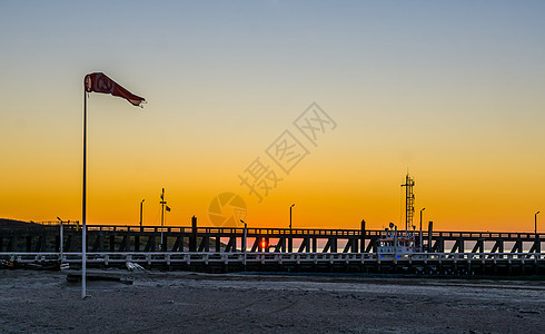 比利时布兰肯贝赫海滩上挂着风旗的港口码头 色彩缤纷的日落图片