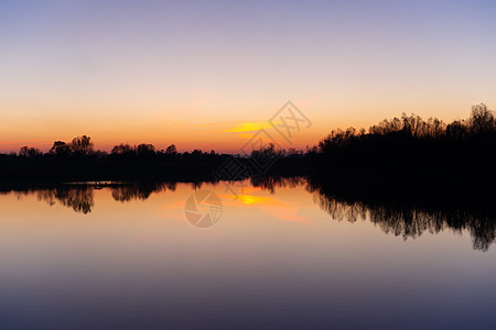 与树和湖的蓝色时间晚上天空风景在前景 蓝色时间日落 完美的蓝绿色和橙色 低光曝光不足的照片戏剧性橙子库存日光太阳海景风暴紫色旅行图片