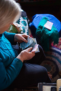 白发老女人手里握着乌克兰纸币 妇女是可悲的 在村里生活悲惨 年老不妙 低光照片村庄文化老年女性贫困白色祖母女士桌子长老图片
