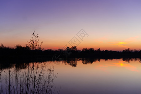 与树和湖的蓝色时间晚上天空风景在前景 蓝色时间日落 完美的蓝绿色和橙色 低光曝光不足的照片海洋库存风暴橙子戏剧性紫色旅行日光太阳图片