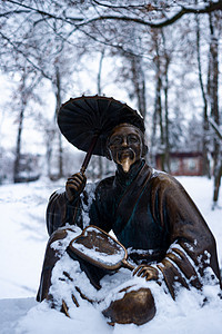 冬雪公园一个带雨伞的中国老人的铜质纪念碑 其背景模糊而封闭寺庙旅游石头地标文化雕塑青铜男人艺术哲学家图片