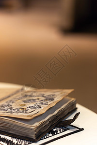 手工制作的魔法笔记本 封面上有塔符号 皮革封面和里面的手工床单 笔记本的第一页有 12 个星座 非常模糊的背景 软焦点放在笔记本图片