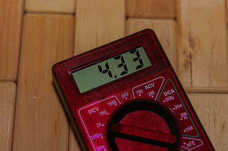 木地板上的红色数字测量万用表 它显示 4 33V 或充满电的电池 包括电压表电流表欧姆表图片
