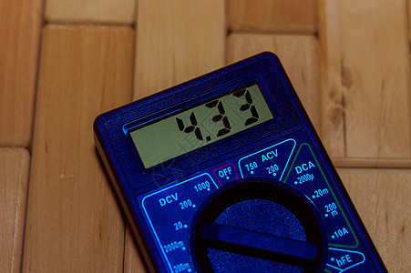 木地板上的蓝色数字测量万用表 它显示 4 33V 或充满电的电池 包括电压表电流表欧姆表图片