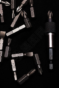 工具碳钢比特 用深色键盘样式在黑色背景上挂有位元工业钻头乐器硬件工具螺丝刀团体金属工作工具箱图片