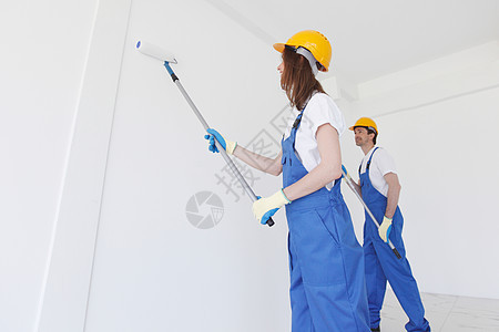 工人在墙上涂油漆女士维修建设者房子夫妻房间装潢装修工作公寓图片