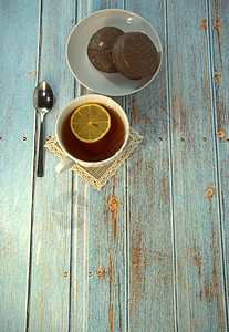 木桌上放着一杯茶和柠檬勺 盘子上放着两块巧克力蛋糕早餐液体食物巧克力桌子柠檬甜点厨房勺子糕点图片