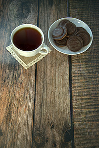 早餐 一杯茶和饼干 还有巧克力冰淇淋 在瓷杯上 躺在木制桌子上液体烹饪饮食甜点营养盘子美食杯子海报食物图片