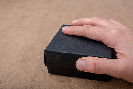 手握着黑色的礼物盒盒子庆典问候语叶子婚礼礼物展示白色惊喜礼品盒图片