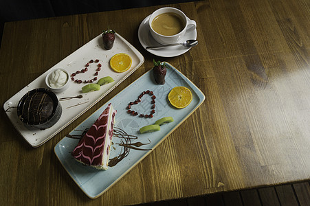餐盘站在切片巧克力蛋糕和饮料上水果桌子托盘奢华奶油午餐花园美食糕点甜点图片