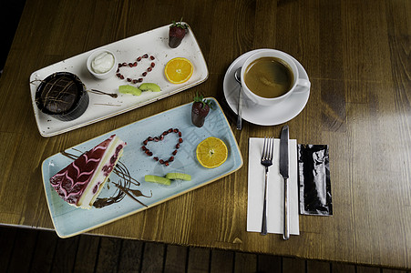 餐盘站在切片巧克力蛋糕和饮料上咖啡餐厅花园美食巧克力桌子盘子奶油文化甜点图片