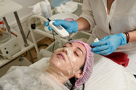 在美容院的年轻女子 做超声波剥皮 和面部清洗程序医生治疗硬件除垢按摩美容师空化沙龙按摩器美容图片