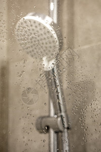 湿玻璃窗后面的清新淋浴 水滴在水上图片